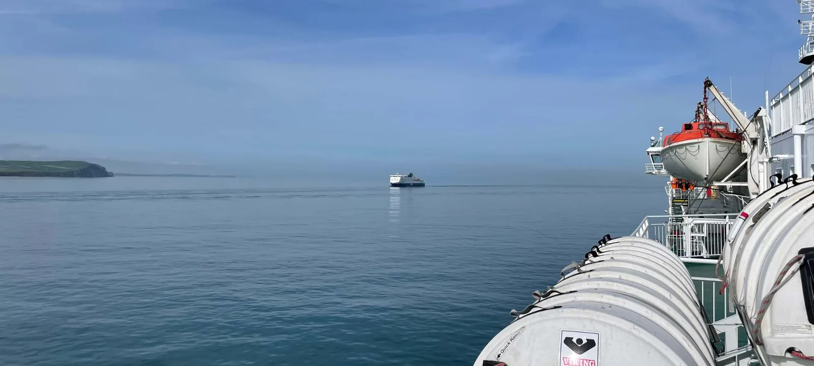 A ferry off the coast near Dover, seen from the deck with the white cliffs on the horizon